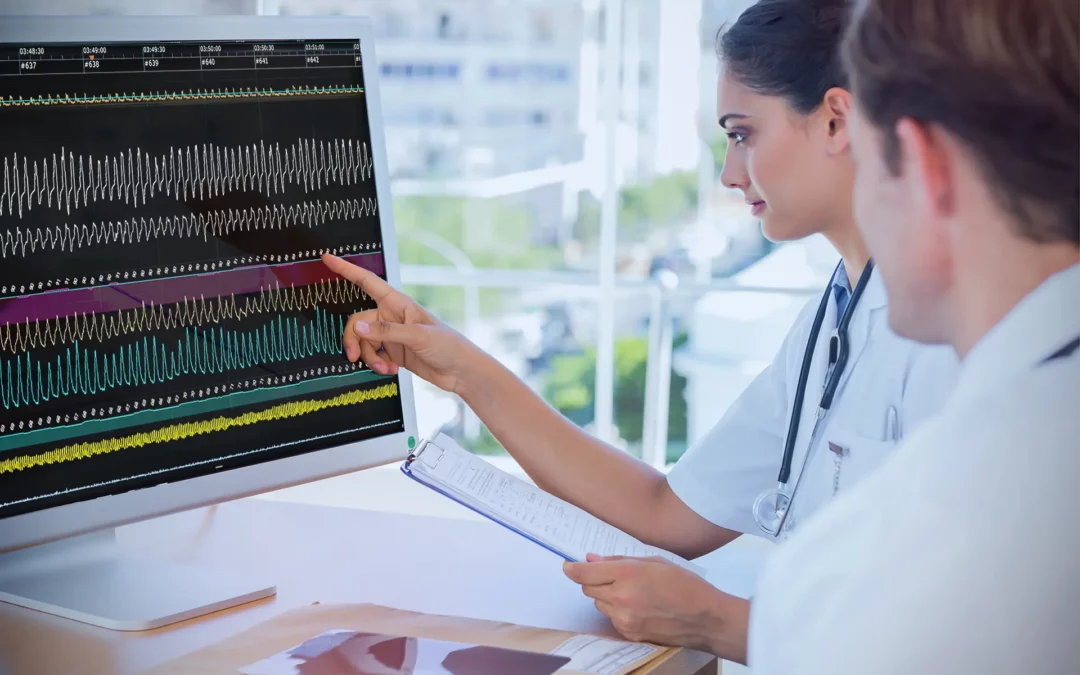 Femme médecin pointant un tracé polygraphique sur un ordinateur